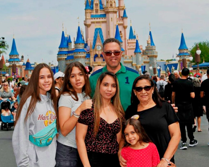 Grupo familiar posando frente al Castillo de Cenicienta en Magic Kingdom durante el día.