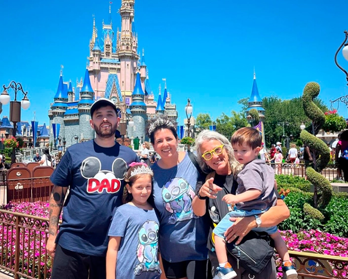 Familia posando frente al Castillo de Cenicienta en Magic Kingdom en un día soleado.
