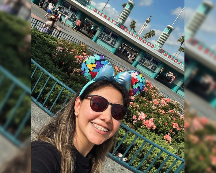 Mujer con orejas de Minnie posando frente a la entrada de Disney’s Hollywood Studios.