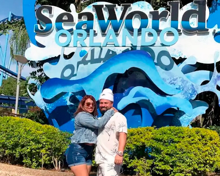 Pareja posando frente al letrero de SeaWorld Orlando.